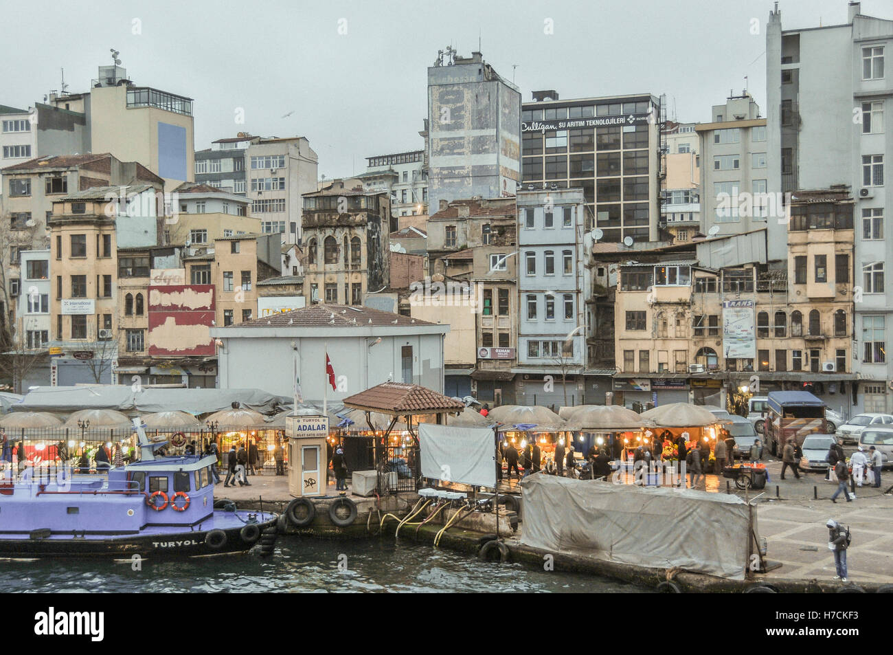 Vista parziale del Golden Horn lungomare con le bancarelle illuminate di Karaköy mercato del pesce dal bordo dell'acqua vicino al Ponte di Galata ( Foto Stock