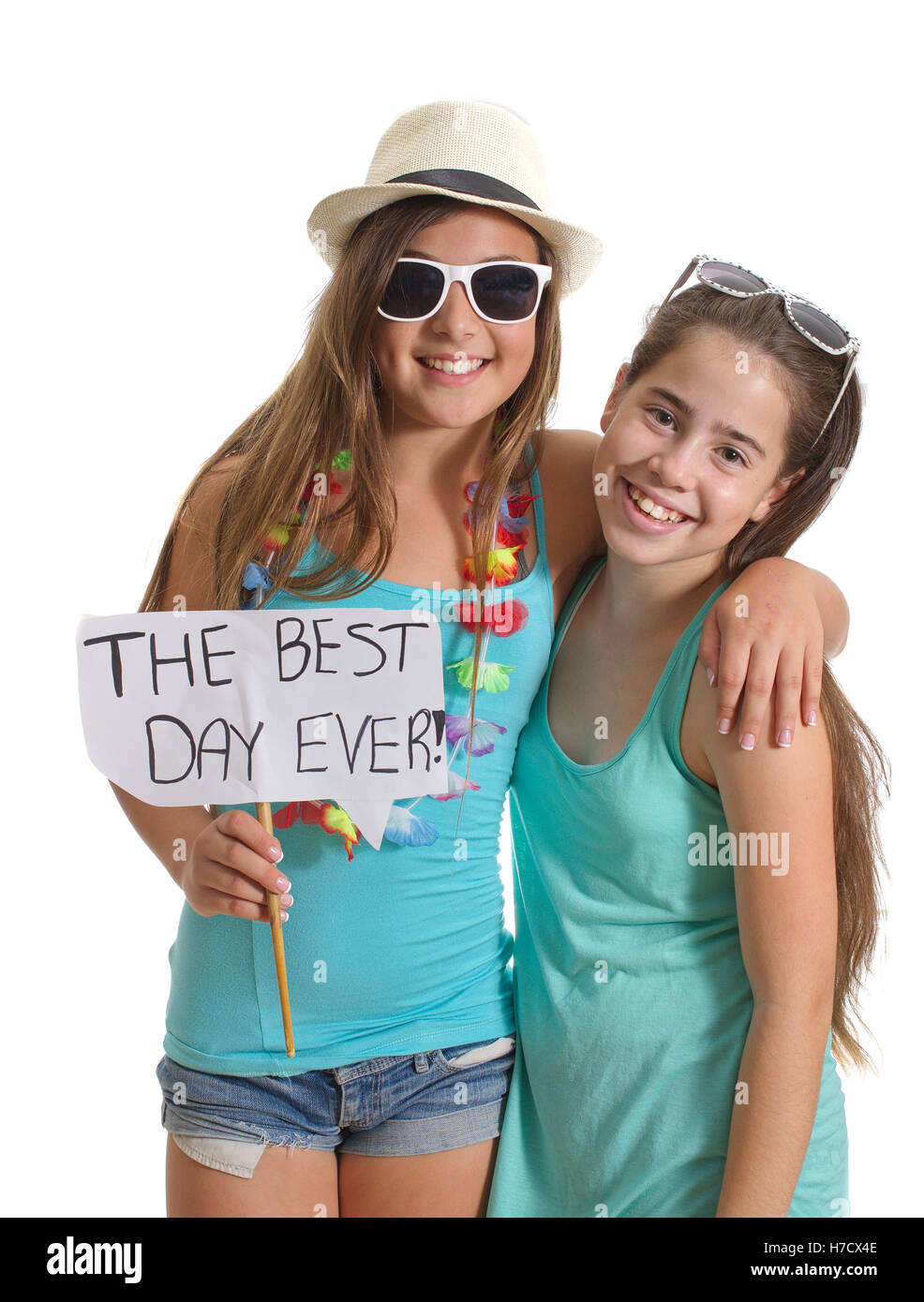 Due migliore amico ragazze in abiti estivi avente un grande tempo tenendo un 'il giorno migliore mai!" segno - isolato su bianco Foto Stock