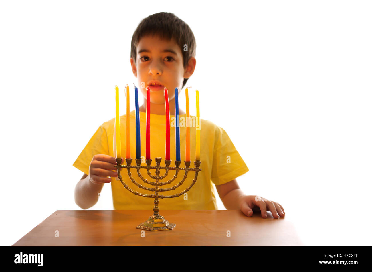 Un Israeliano 8 anno di età del bambino una illuminazione Hanukkah Menorah Foto Stock