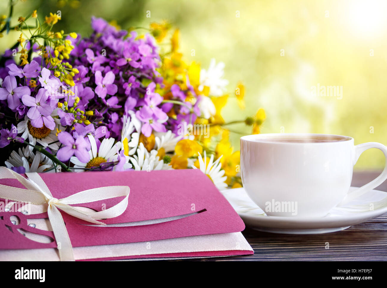 Tazza di caffè, fiori selvatici e una busta Foto Stock