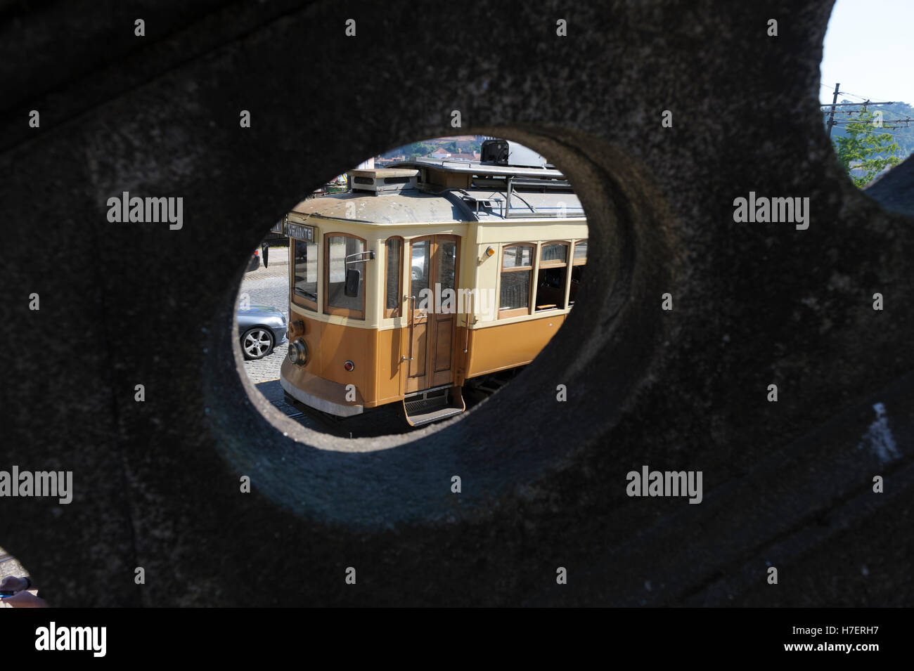 Tradizionale vecchio tram elettrico visto attraverso la balaustra in pietra a Porto, Portogallo Foto Stock