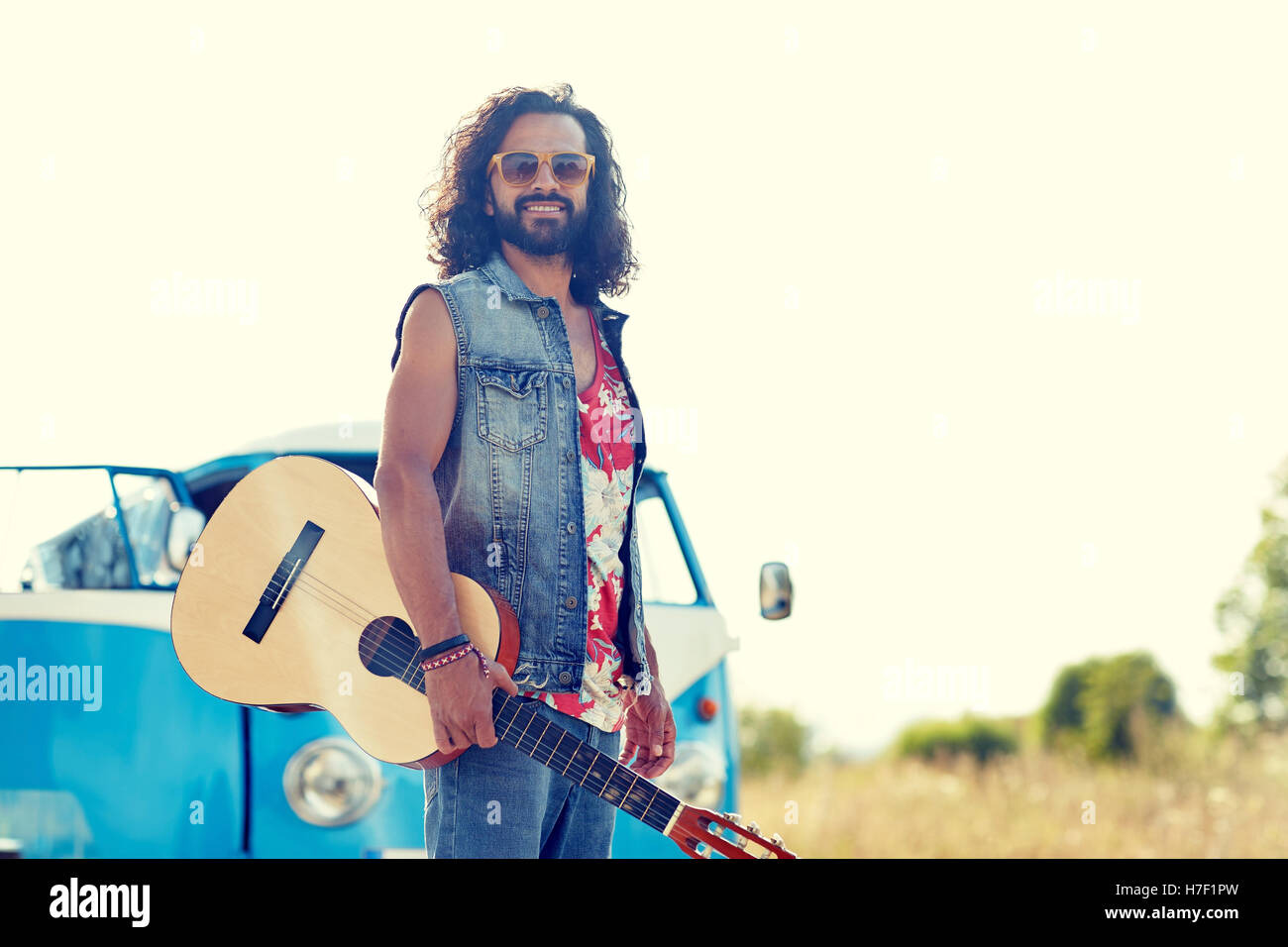 Hippie uomo con chitarra su minivan auto all'aperto Foto Stock