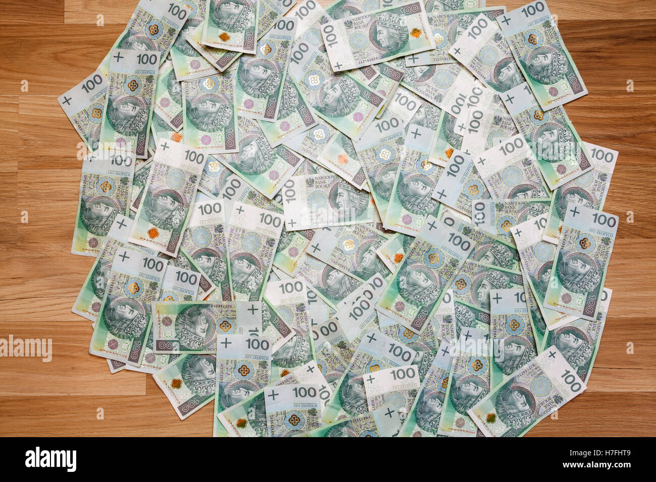 Sfondo di denaro fatte di un centinaio di zloty polacco (PLN) fatture su pavimento in legno Foto Stock