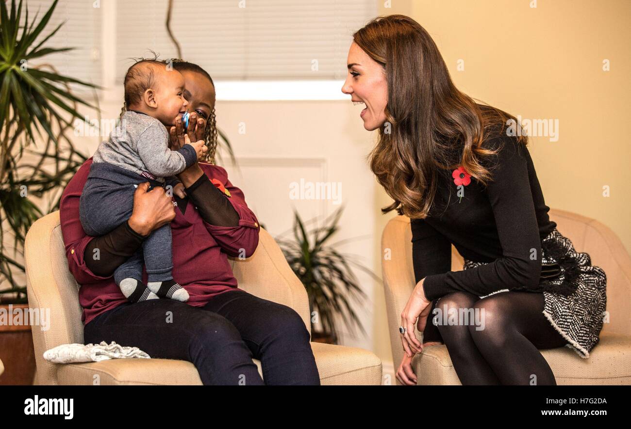 La Duchessa di Cambridge rende facce a quattro mesi di età come Gabriel parla a sua madre Hlengiwe Sithole al Nelson fiducia Centro per le donne a Gloucester che è progettato per sostenere le donne che hanno problemi di vulnerabilità, in particolare di coloro che hanno sperimentato gli abusi e traumi. Foto Stock