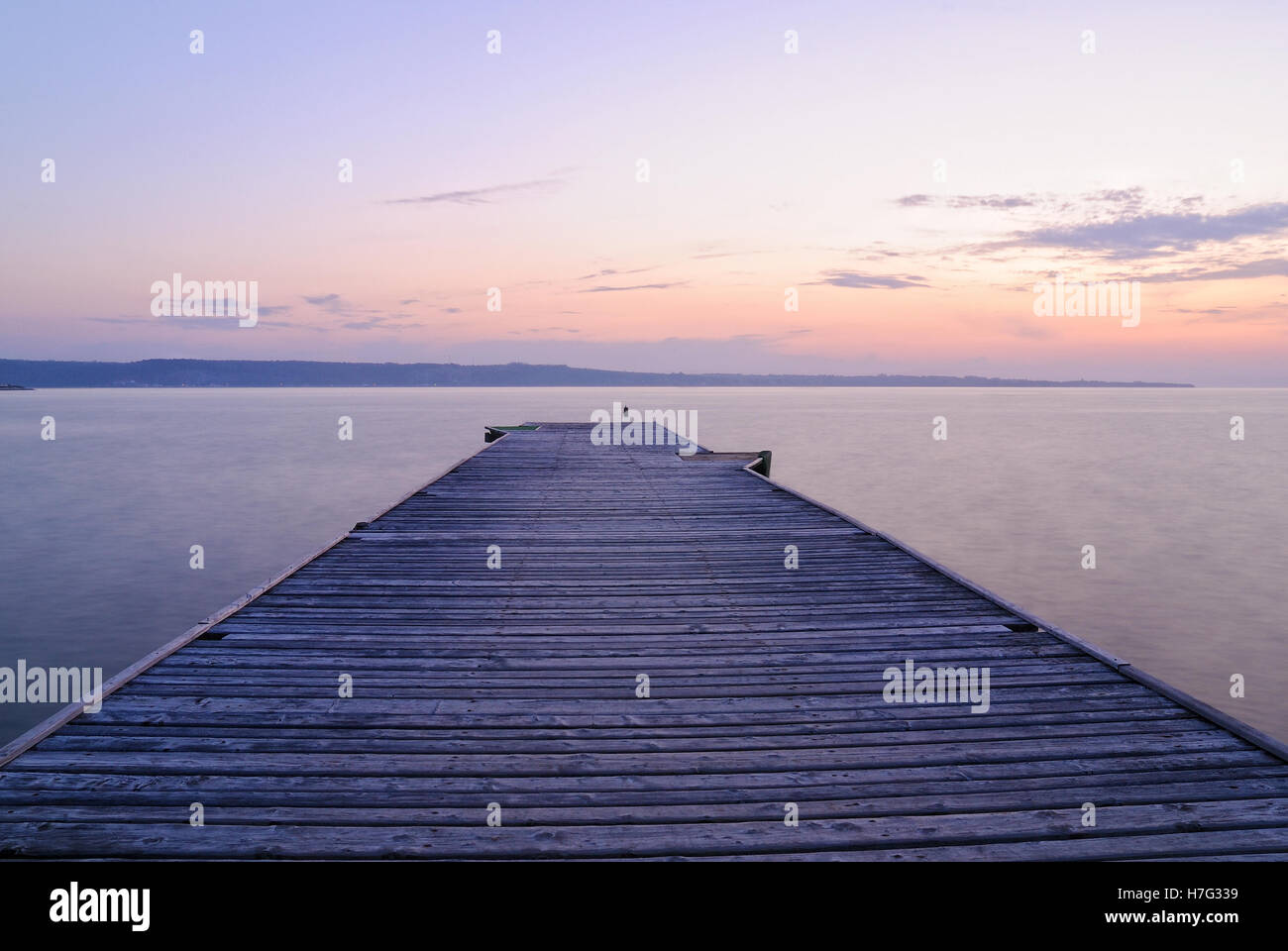 Vecchio pontile in legno sul lago al tramonto Foto Stock