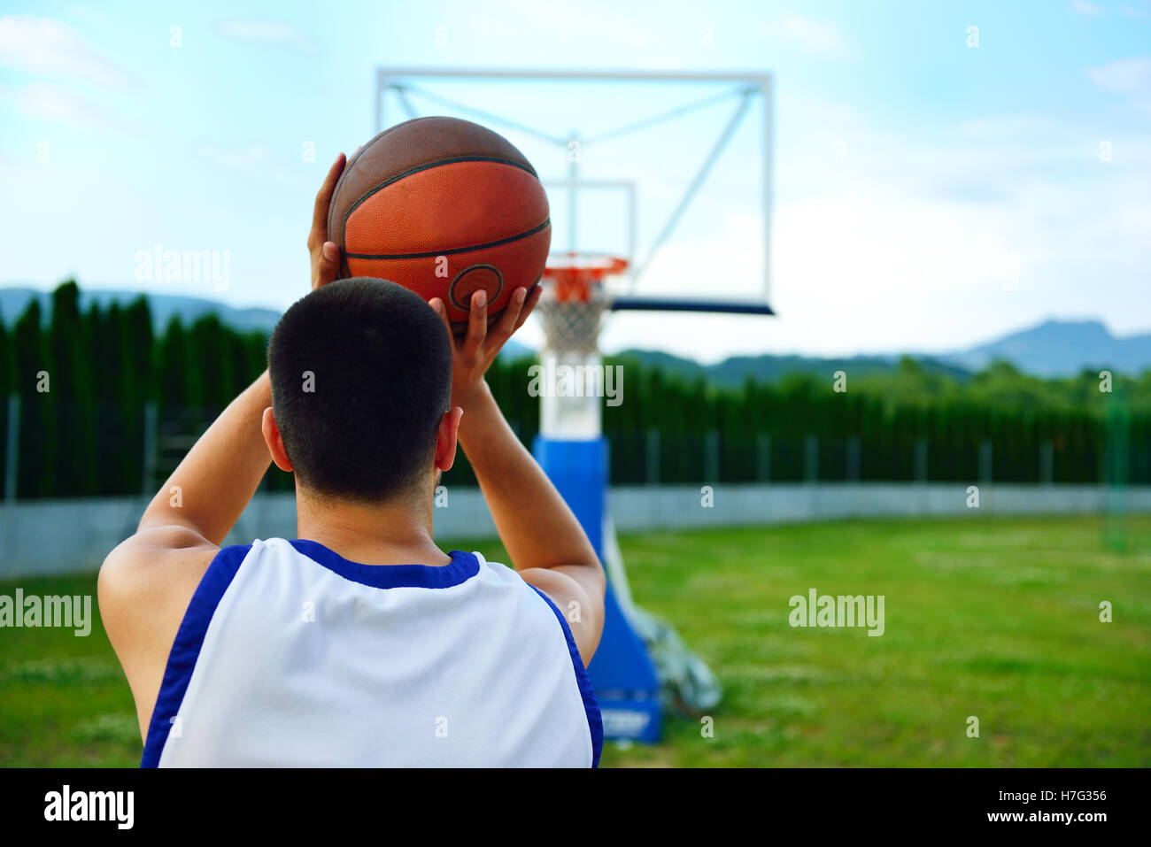 Vista posteriore di un giocatore di pallacanestro, tiro a canestro outdoor  Foto stock - Alamy