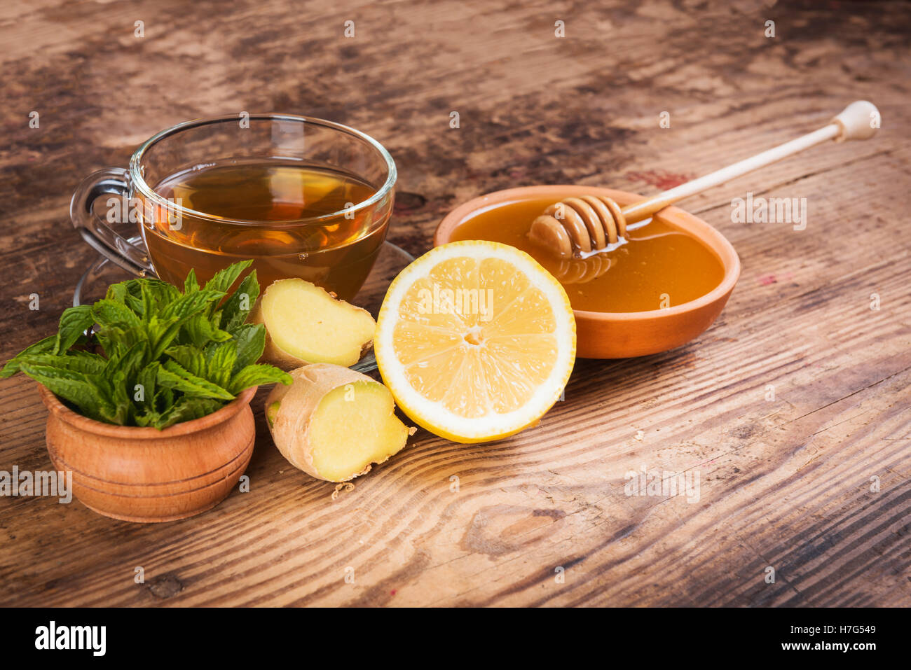 Il tè verde tazza di miele zenzero limone sfondo di legno Foto Stock
