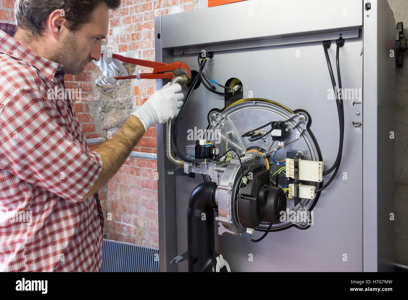 Plumber chi effettua la manutenzione di una caldaia a condensazione Foto Stock