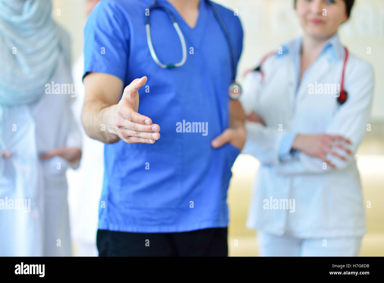 Amichevole maschio medico con una mano aperta pronta per avvolgente Foto Stock