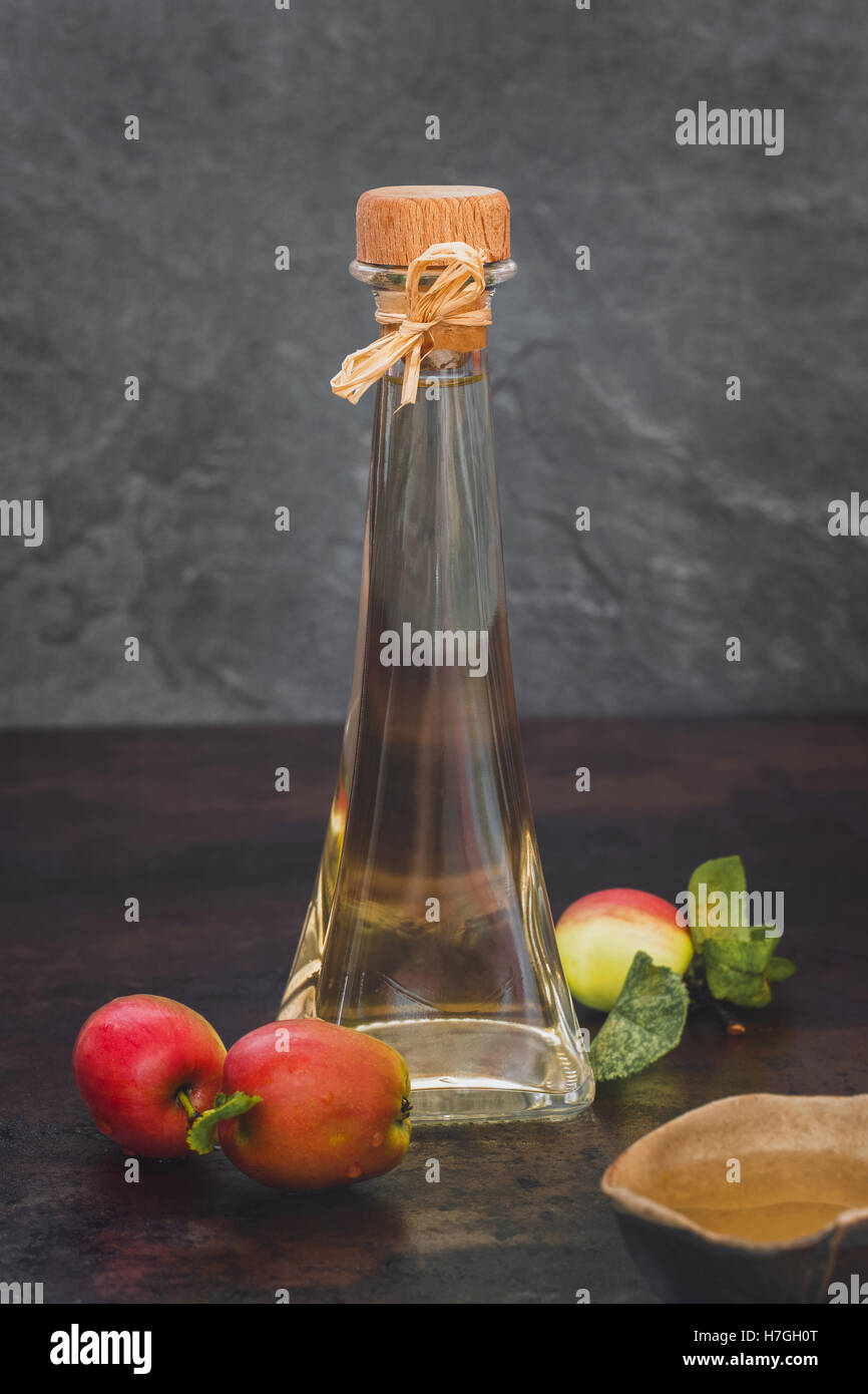 Aceto di mele. Bottiglia di apple aceto organico su sfondo rustico Foto Stock