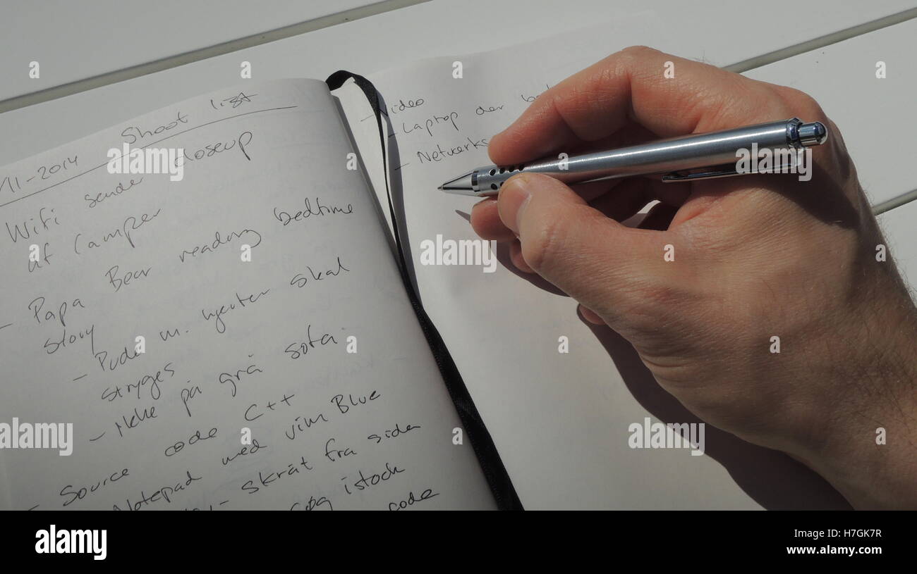 Prendendo alcune note nel registro idea notebook - uno strumento per la mente creativa. Foto Stock