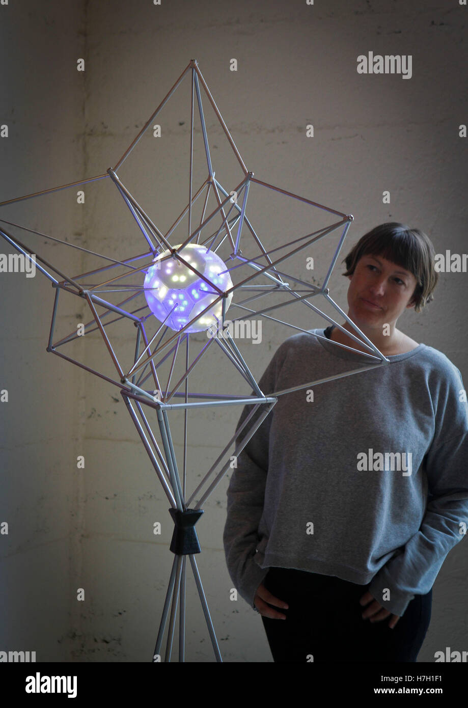 Vancouver, Canada. 4 Novembre, 2016. Una donna prende uno sguardo a un design vincente dalla lampada del quarto annuale internazionale di design di illuminazione la concorrenza a Vancouver in Canada, nov. 4, 2016. Disegni premiati dalla lampada del quarto annuale internazionale di design di illuminazione la concorrenza sotto il tema 'cosmic" erano visualizzati in Vancouver. Credito: Liang Sen/Xinhua/Alamy Live News Foto Stock