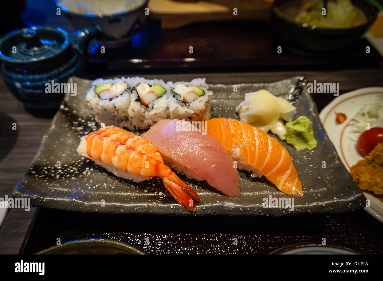 Piastra del nigiri sushi con Ebi (gamberetti), Maguro (tonno) e sake (salmone) in una sala da pranzo giapponese di impostazione. Foto Stock