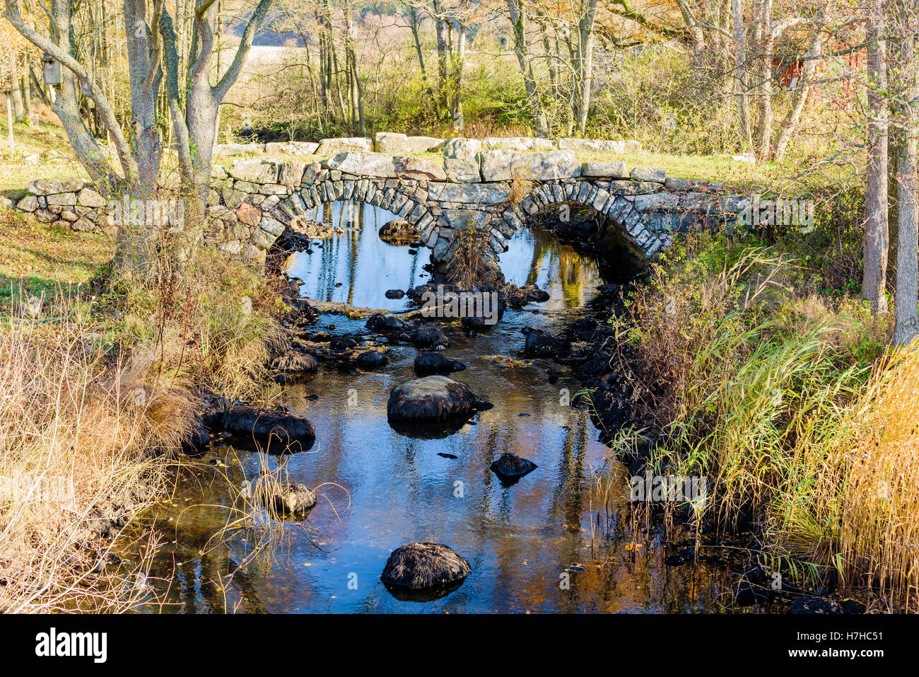 Vecchio arcuata doppio ponte in pietra sopra una piccola e bassa corrente in caduta. Vieryd appena fuori Ronneby, Svezia. Foto Stock