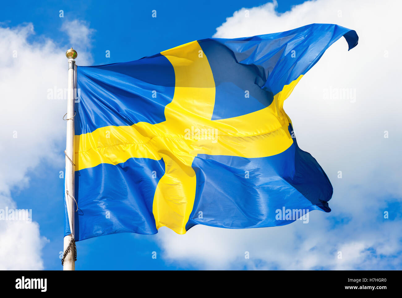 Bandiera svedese blu con croce gialla sventolare nel vento contro un cielo  azzurro sfondo con il cloud Foto stock - Alamy