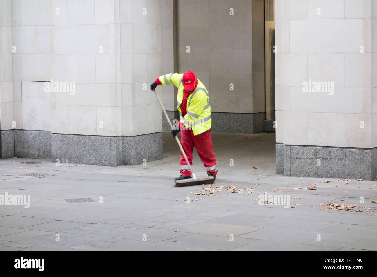 Workman ampie foglie in san Paolo sagrato, città di Londra, Regno Unito Foto Stock