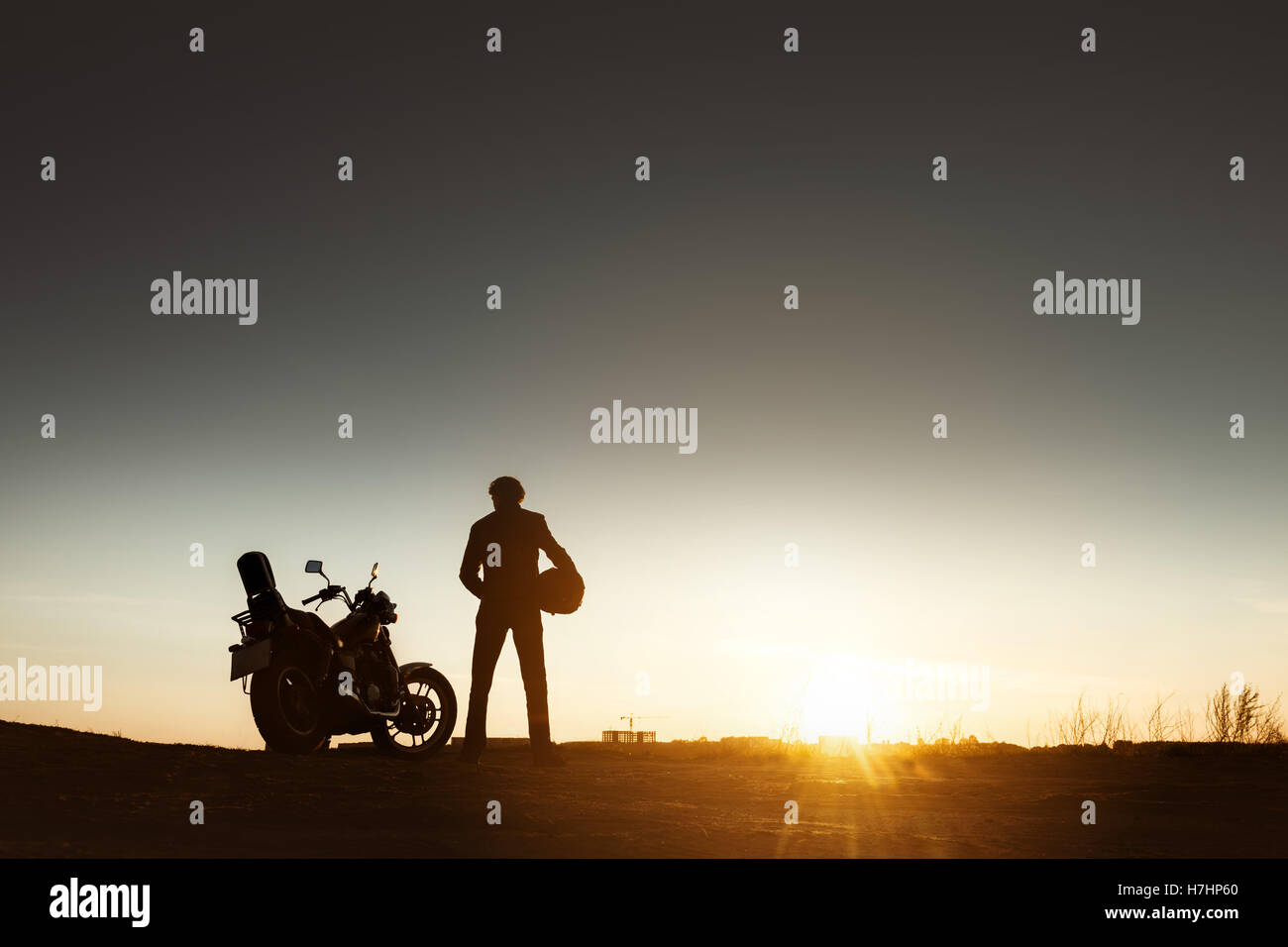Biker la sagoma del motociclo con il tramonto Foto Stock