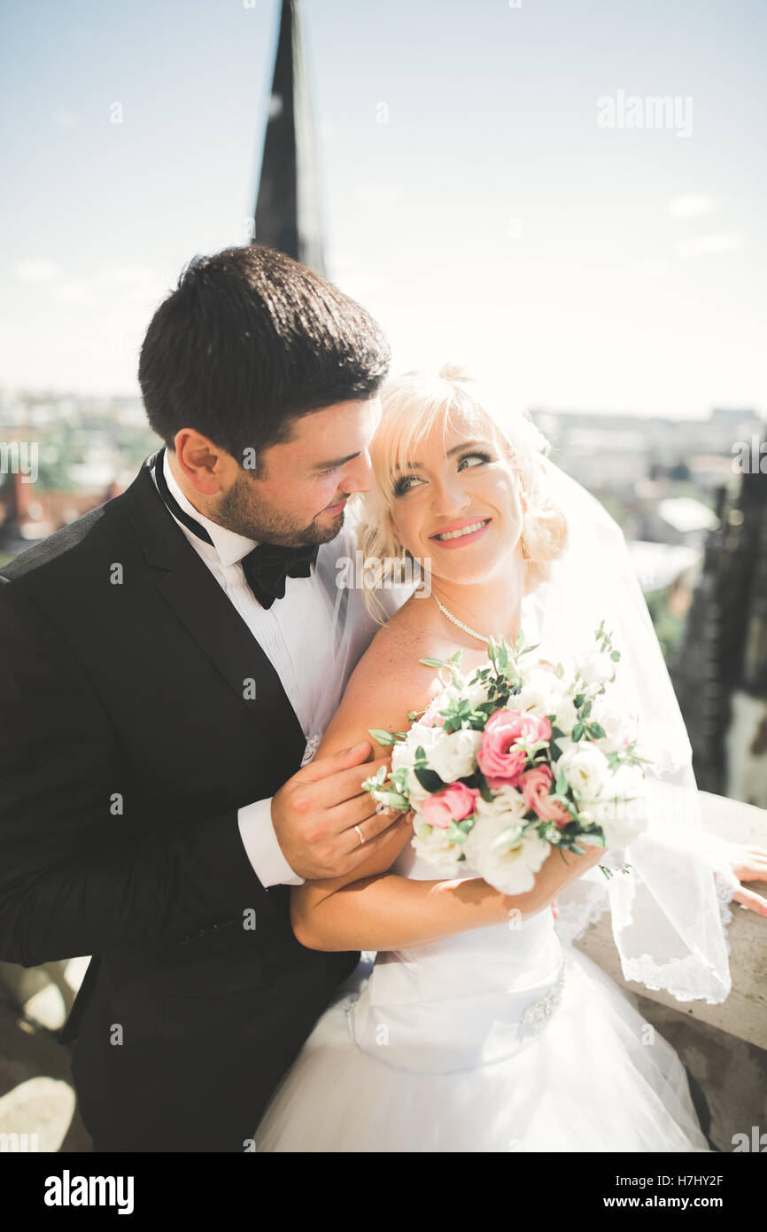 Bella ed elegante sposi baciando e abbracciando sullo sfondo vista panoramica della città vecchia Foto Stock
