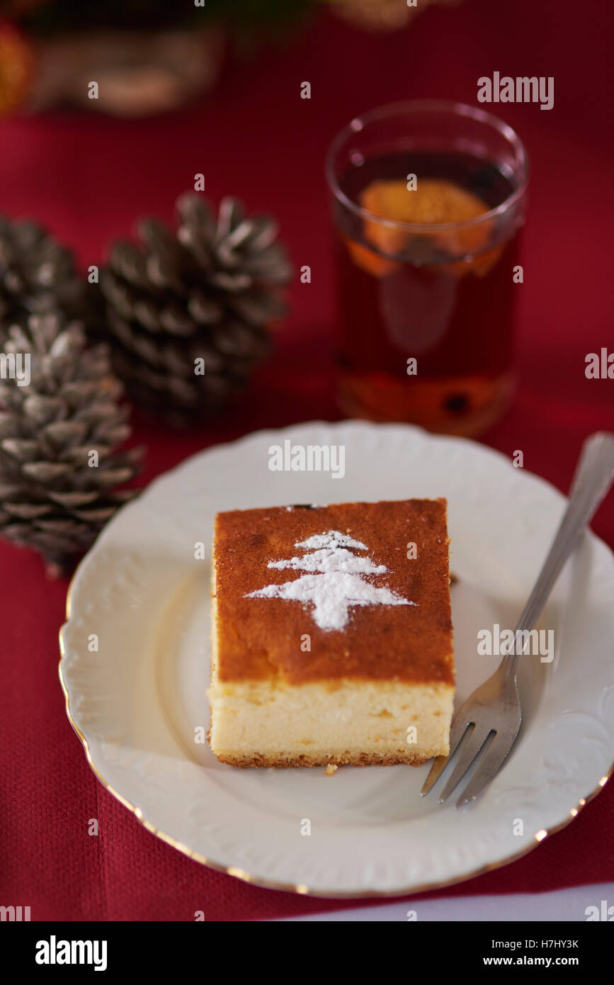 Lo zucchero in polvere di forma sul pezzo di cheesecake Foto Stock