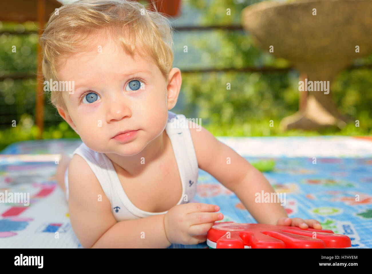 Magnifico bambino otto mesi strisciando nel giardino,vicino. Foto Stock