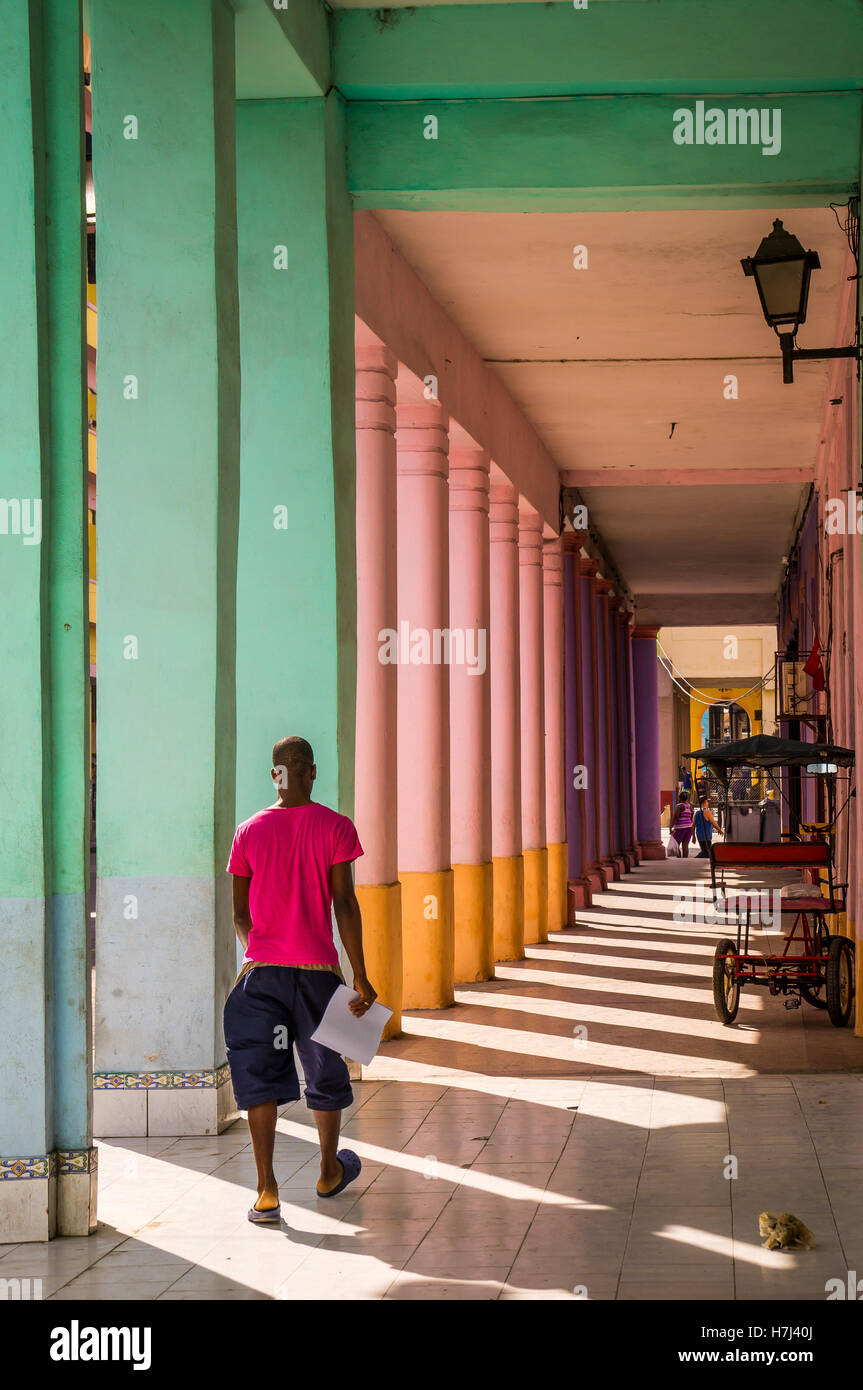 Uomo cubano camminando attraverso colorate passway a l'Avana Foto Stock