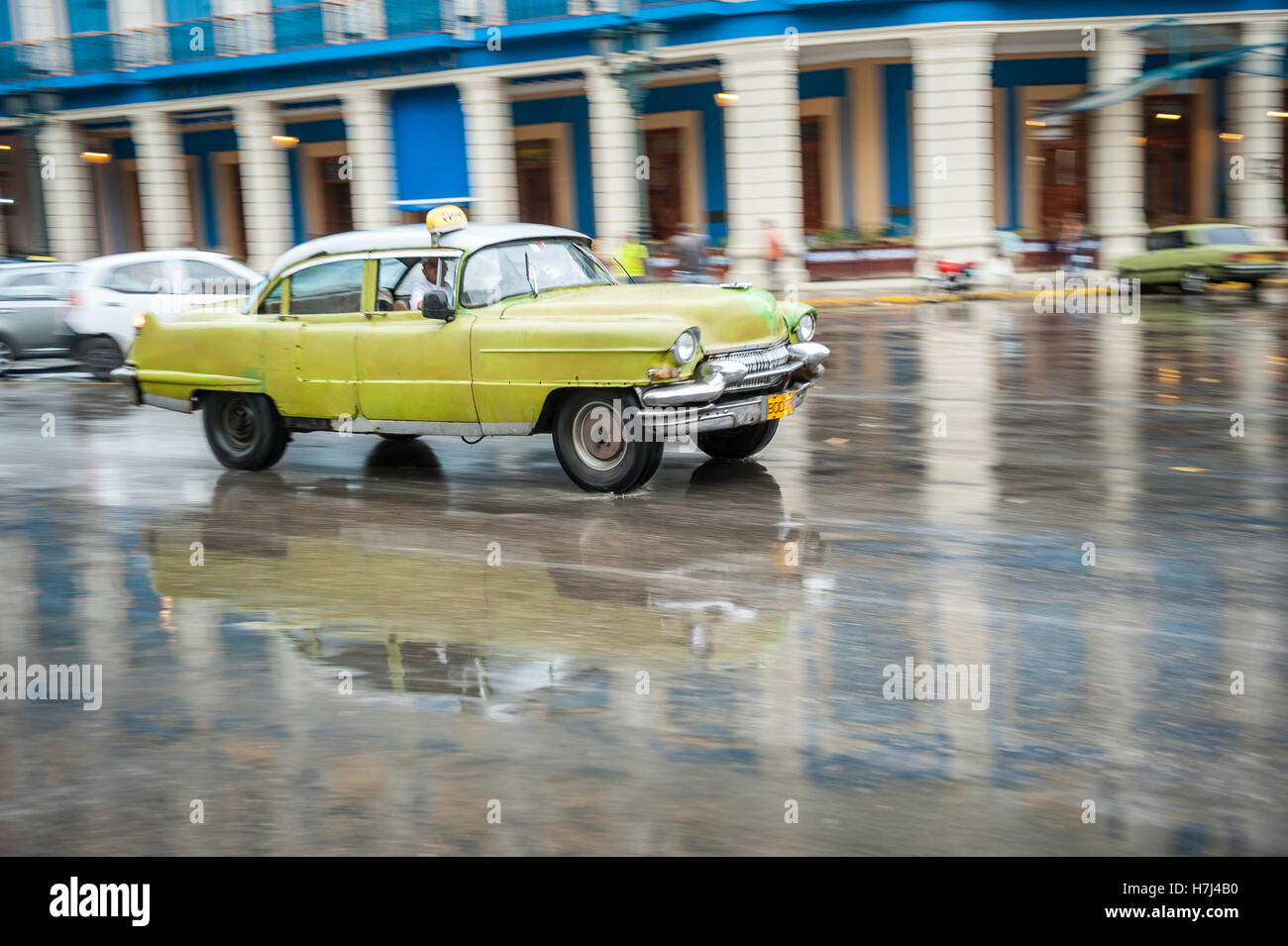 L'Avana, Cuba - 18 Maggio 2011: classica degli anni cinquanta unità auto in motion blur attraverso le strade bagnate di Centro dopo un acquazzone. Foto Stock