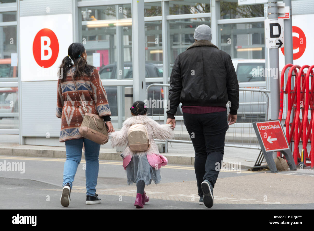 Una famiglia con un bambino piccolo a piedi verso un TFL stazione degli autobus Foto Stock