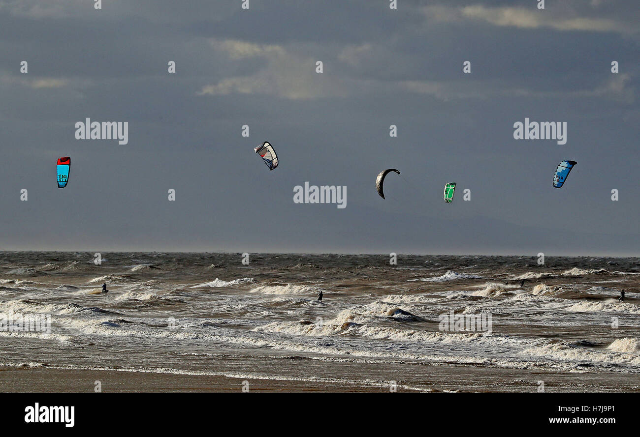 Kite surfers godetevi il forte le ali e ruvide fiume Mersey delle onde sulle sabbie del New Brighton, Wirral, come fuochi d'artificio ventilatori può essere necessario stringersi un po' più vicino al falò sulla notte di sabato, con temperature attese a tuffo per congelamento attraverso parti del Regno Unito. Foto Stock