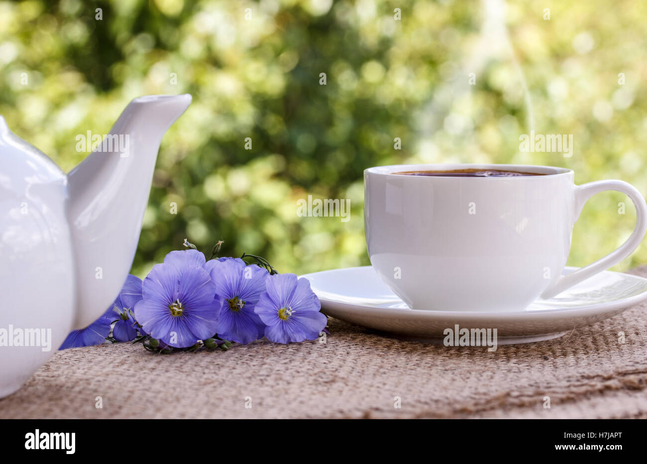 Tazza da caffè con fiori blu e note di buona mattina blu sul tavolo rustico da sopra, prima colazione Foto Stock