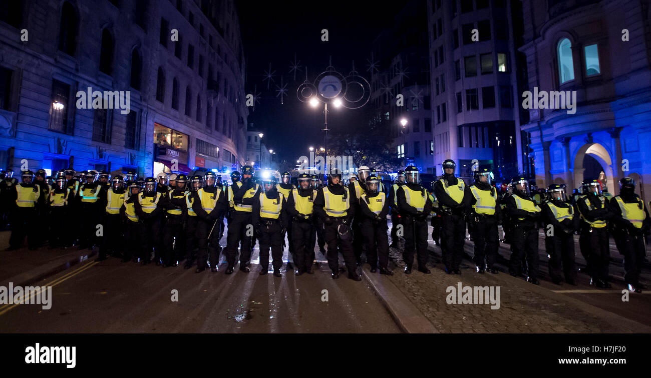 La polizia sullo Strand, Londra, durante la maschera di milioni di marzo notte dei falò protesta organizzata dal gruppo attivista anonimo. Foto Stock