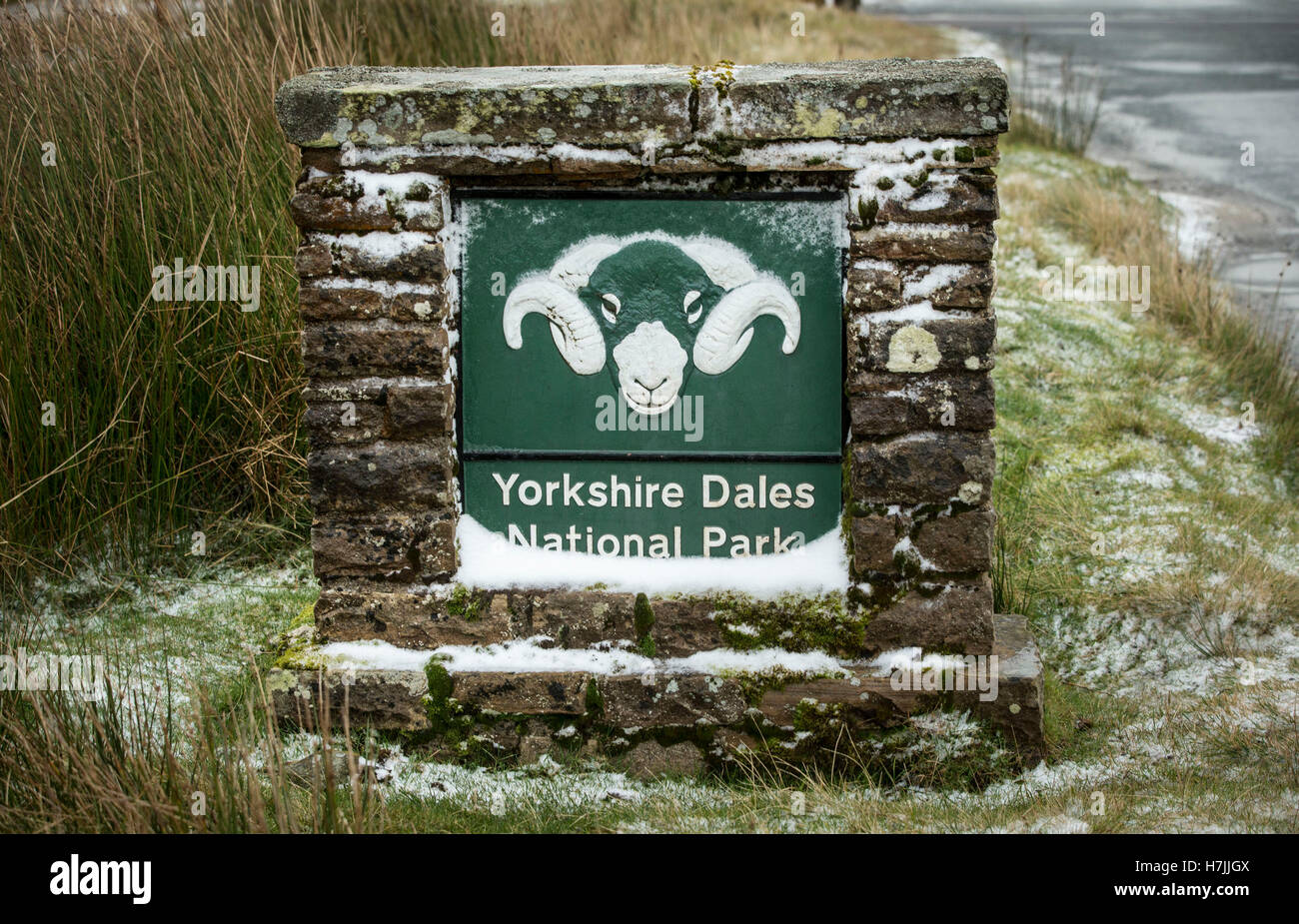 Una leggera spolverata di neve su un segno per le Yorkshire Dales National Park vicino a Tan Hill nel North Yorkshire. Foto Stock