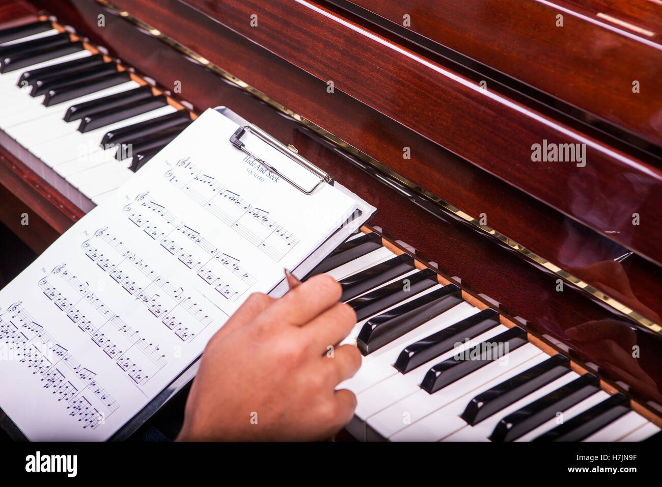 L'uomo suonando piano sintonia con penna a sfera nella mano destra da notes penna nera nascondino Foto Stock