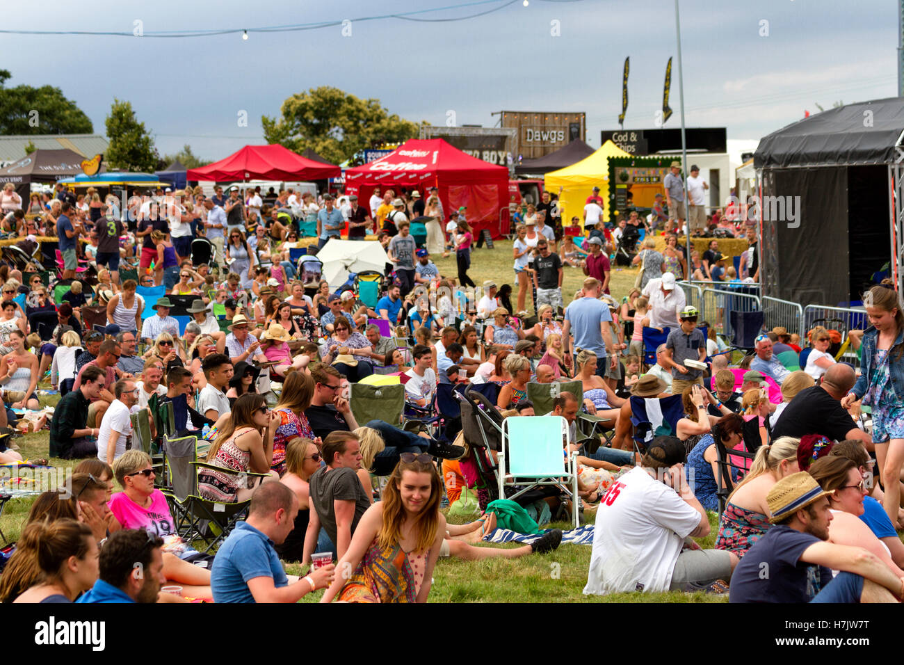 Pubblico di relax presso la salsiccia annuale e Beer Festival di musica, Jimmy's Farm, Ipswich, Suffolk, Regno Unito Foto Stock