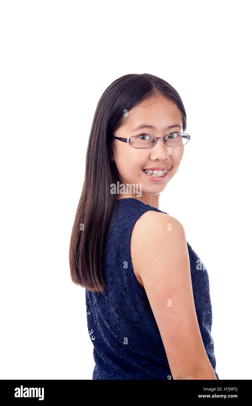 Carino ragazza asiatica in parentesi graffe colpisce un fiducioso pongono, isolato su bianco. Foto Stock