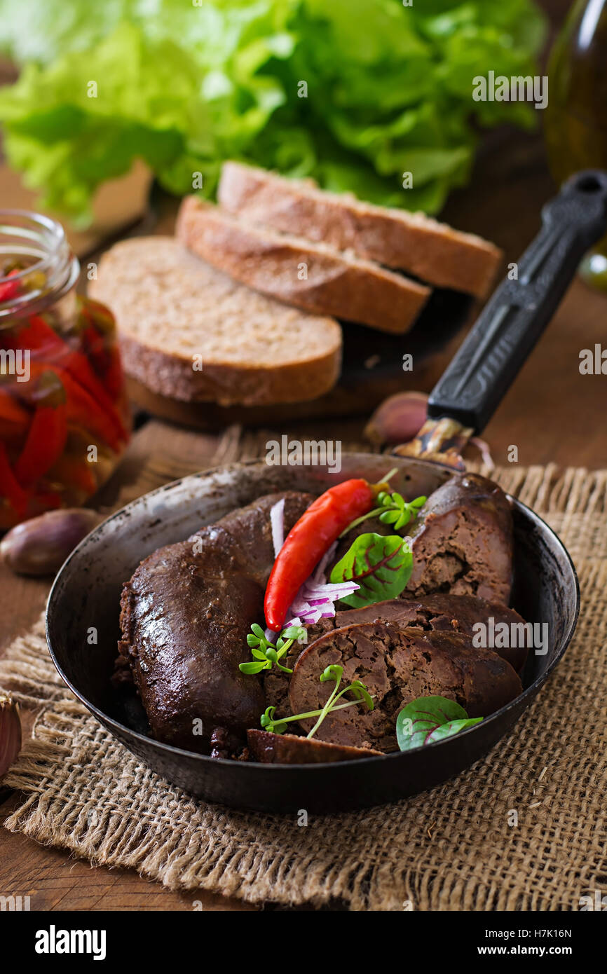 In casa la salsiccia di sangue con le frattaglie sul vecchio sfondo in legno in stile rustico Foto Stock