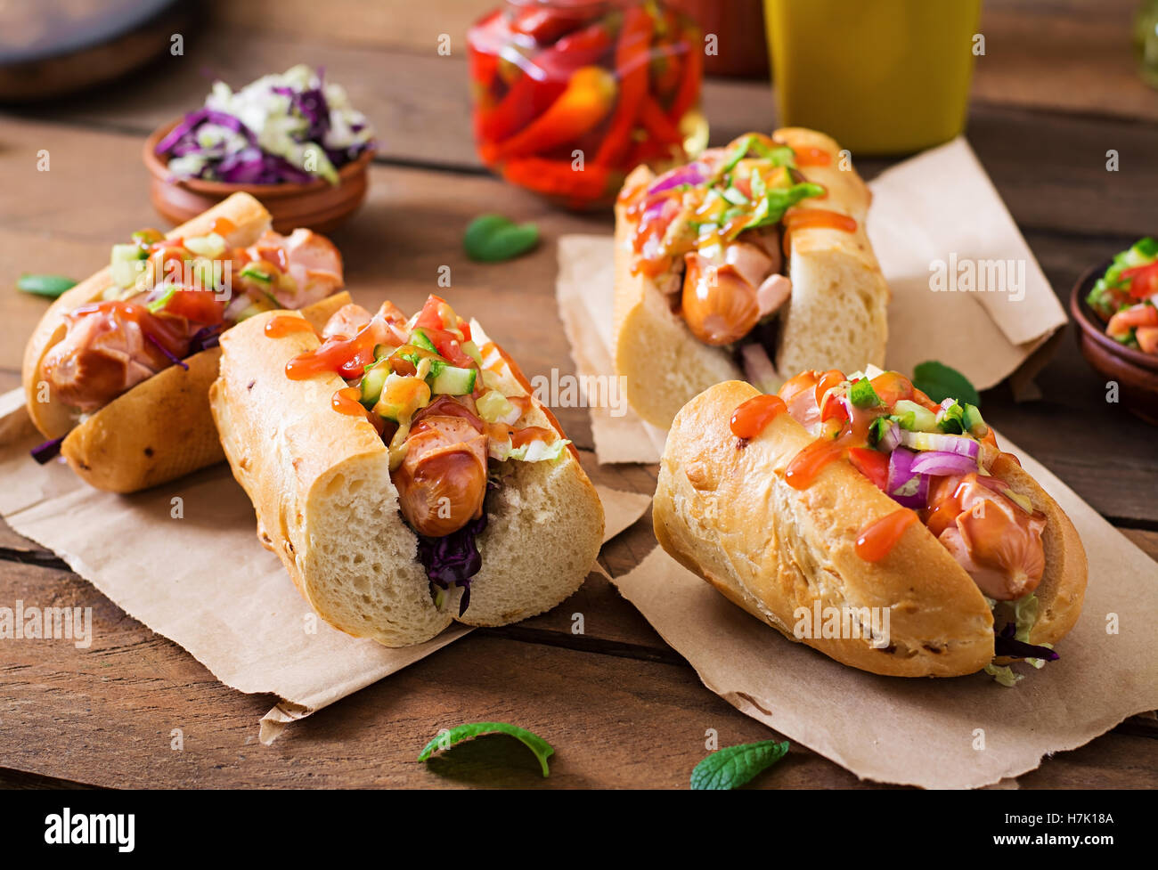 Hot Dog - sandwich con salsa messicana su sfondo di legno. Foto Stock