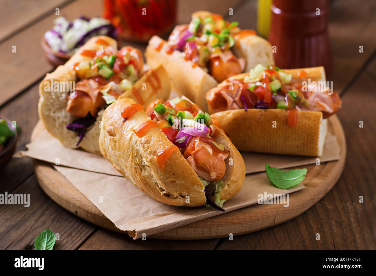 Hot Dog - sandwich con salsa messicana su sfondo scuro. Foto Stock