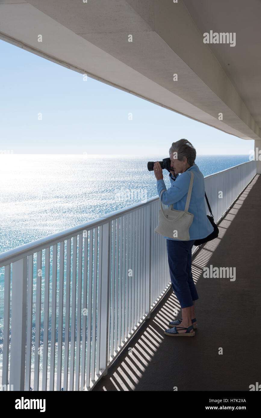 Costa del Golfo della Florida USA Donna prendendo una foto del Golfo costa da un grattacielo balcone Foto Stock