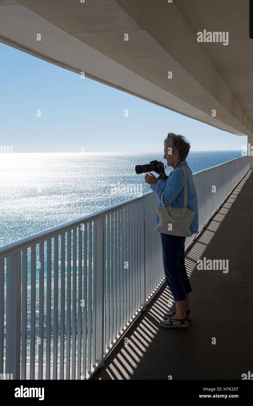 Costa del Golfo della Florida USA Donna prendendo una foto del Golfo costa da un grattacielo balcone Foto Stock
