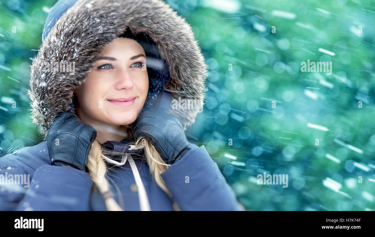 Closeup ritratto di una donna bellissima godendo di inverno, indossa una giacca calda con cappa pelliccia in caso di neve all'aperto, vacanze inverno Foto Stock