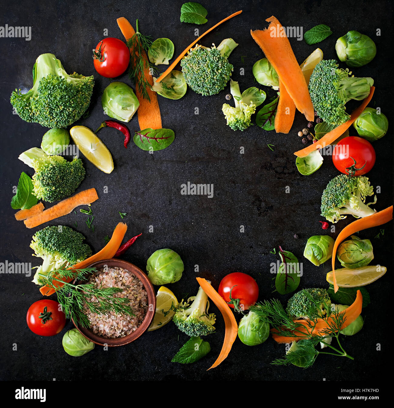Verdure fresche per una dieta sana su uno sfondo scuro in stile rustico. Cibo vegetariano. Vista superiore Foto Stock