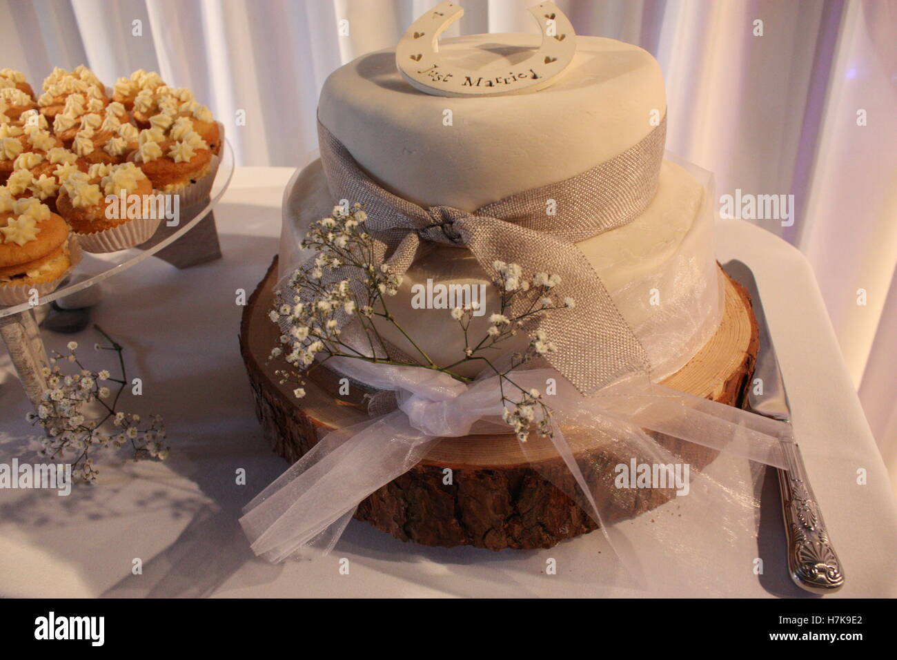 Appena sposata con il ferro di cavallo sulla parte superiore di una torta di nozze stand di registro Foto Stock