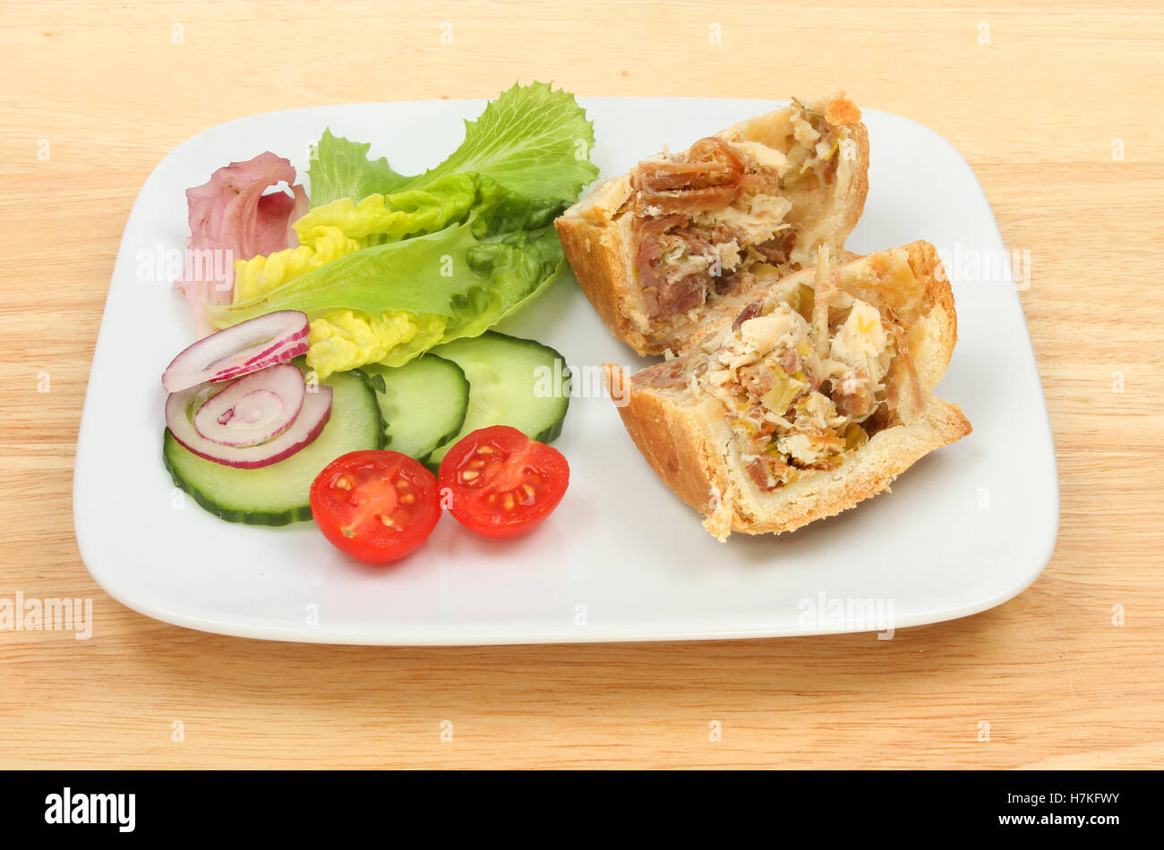 Pollo e torta di prosciutto con insalata su una piastra su un tavolo in legno Foto Stock