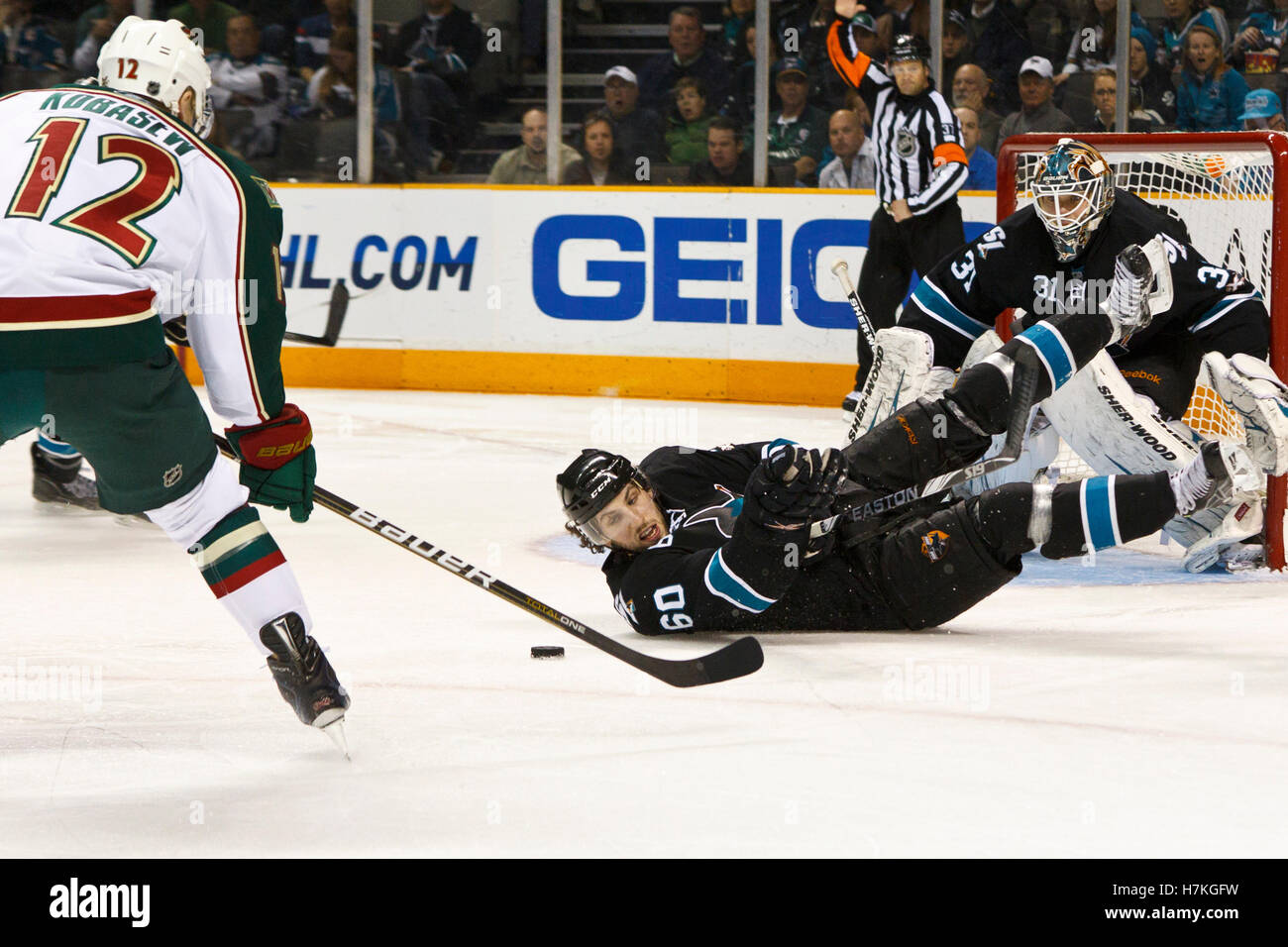 Marzo 17, 2011; San Jose, CA, Stati Uniti d'America; Minnesota Wild ala destra Chuck Kobasew (12) prende il puck da San Jose Sharks defenceman Jason Demers (60) durante il terzo periodo a HP Pavilion. San Jose sconfitto Minnesota 3-2. Foto Stock