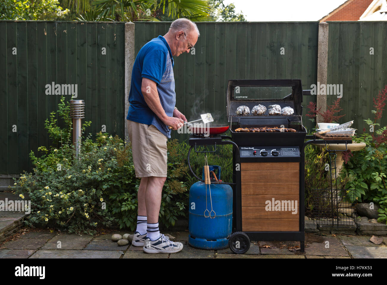 Uomo maturo per la cottura su un barbecue Foto Stock