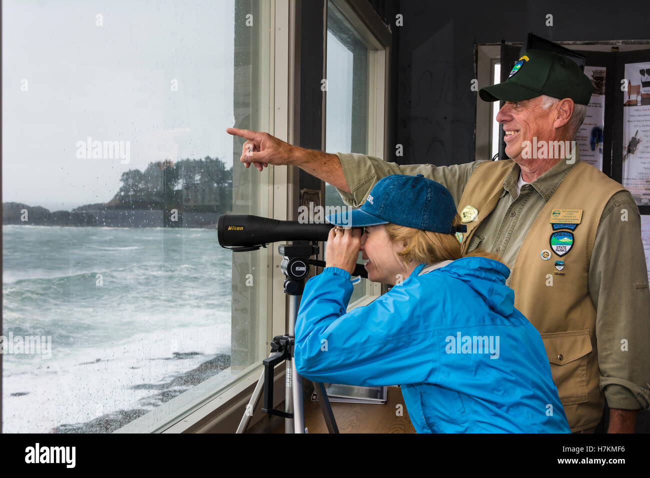 Parchi statali volontario aiutare il visitatore cerca per uccelli marini e le balene con un cannocchiale a Depoe Bay Whale Watch centro sulla costa dell'Oregon. Foto Stock