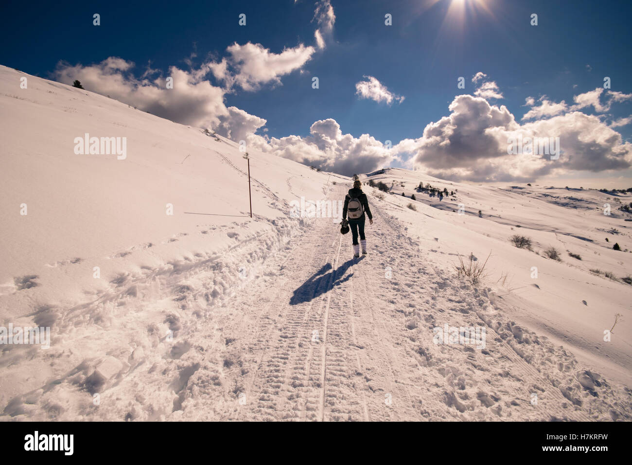 Donna passeggiate in montagna su un sentiero innevato. Foto Stock