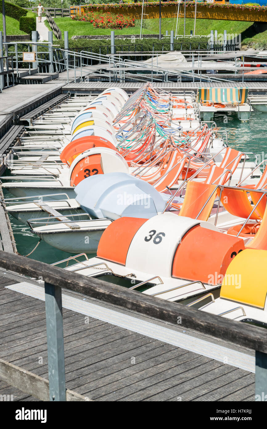 Pedale barca parcheggiata in una lunga linea presso il bacino del lago. Foto Stock
