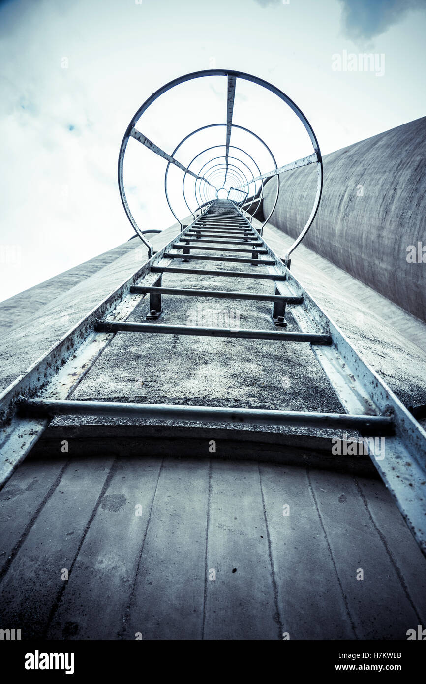 Esterno del vecchio edificio industriale con scaletta. Architettura di calcestruzzo. Fabbrica abbandonata. Foto Stock