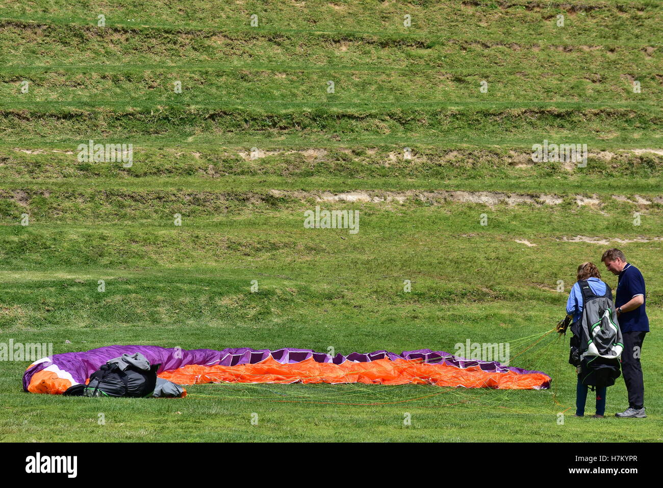 Imparare il parapendio con un coloratissimo paracadute sgonfiato in appoggio sull'erba. Foto Stock